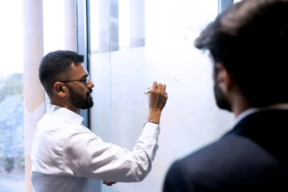 Investment Researcher writing on a glass wall
